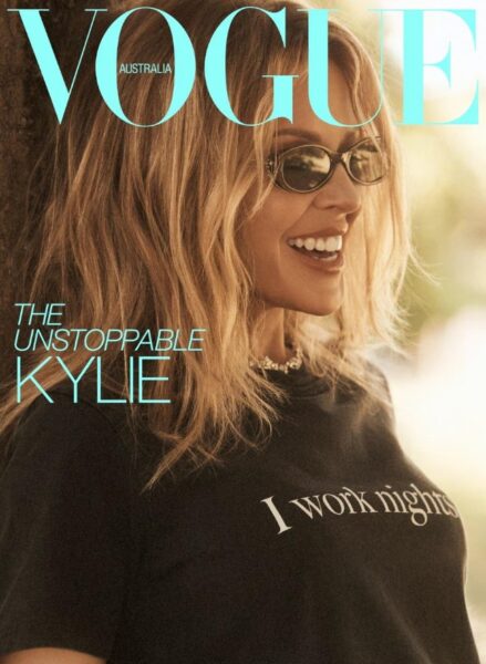 Kylie Minogue nosi plašč in majico Connerja Ivesa; krilo Anne Demeulemeester; sončna očala Chanel; uhane in ogrlico Van Cleef & Arpels.